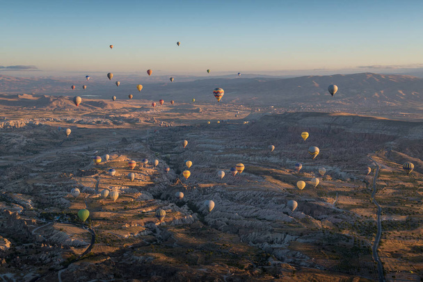 Scenic picture with baloons flying over Cappadocia landscape at the sunrise - Φωτογραφία, εικόνα