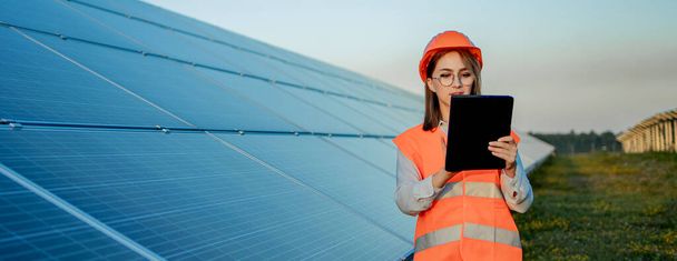 Inspector Engineer Woman Holding Digital Tablet Working in Solar Panels Power Farm, Photovoltaic Cell Park, Green Energy Concept. - Фото, изображение