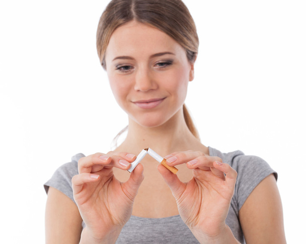 Woman breaking a cigarette (focus on cigarette) - 写真・画像
