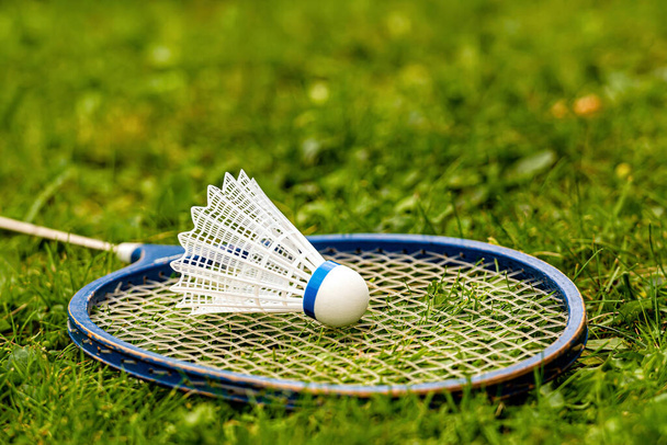 Badminton rackets and shuttlecock on green grass - Foto, afbeelding