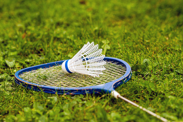 Badminton rackets and shuttlecock on green grass - Фото, зображення