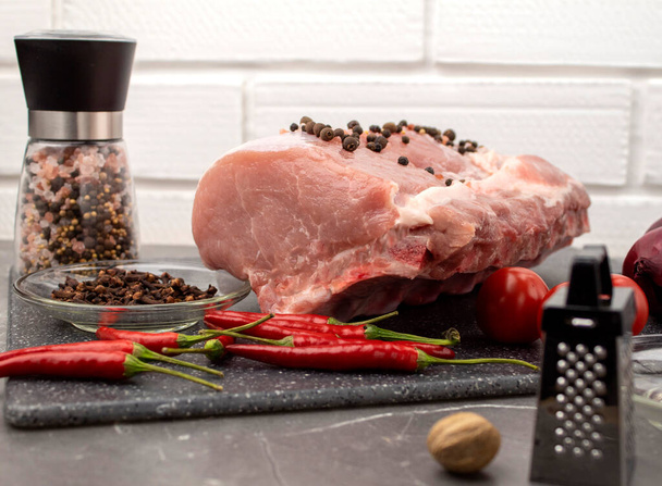 Syrové vepřové maso na mramorové desce s kořením a zeleninou - Fotografie, Obrázek