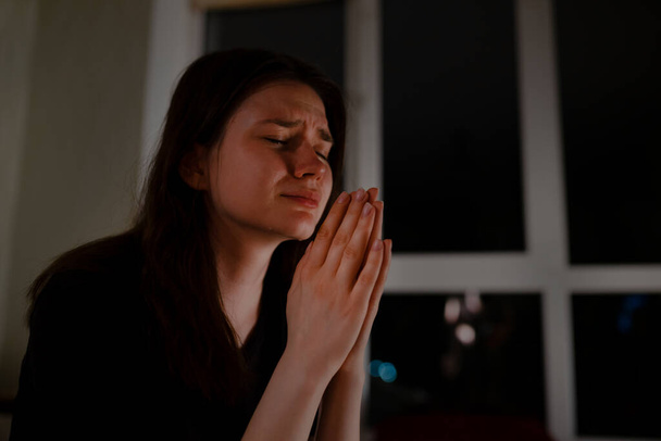 Jeune femme priant et pleurant la nuit - Photo, image