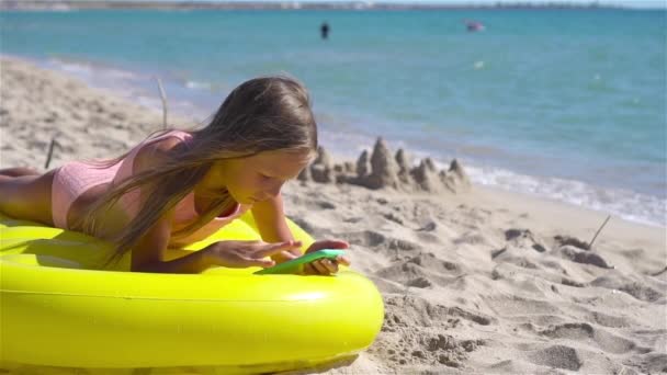 Menina adorável no colchão de ar inflável na praia - Filmagem, Vídeo