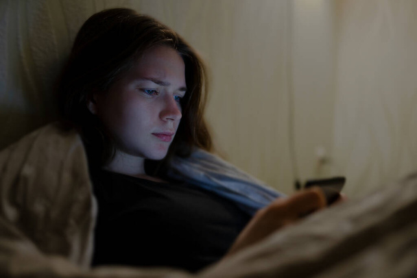 Жінка використовує свій телефон перед сном
 - Фото, зображення