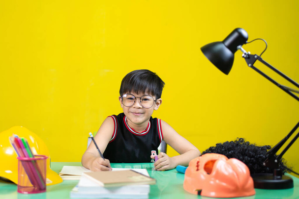 Glückliche Kinder mit Brille bei den Hausaufgaben, Lerngeräte auf dem Tisch. - Foto, Bild