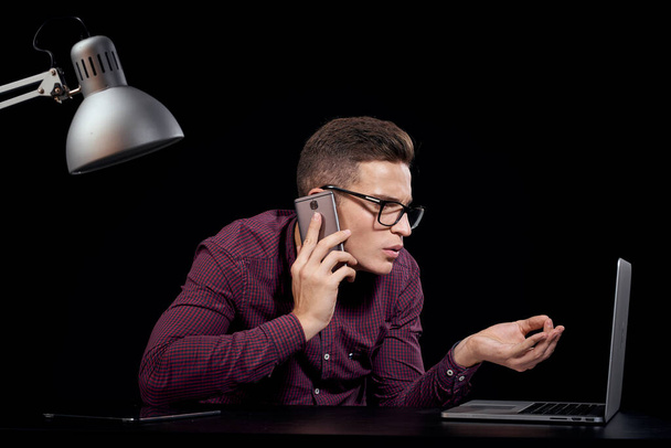 Άντρας διαχειριστής σε εσωτερικούς χώρους σκούρο φόντο επικοινωνία κόκκινο πουκάμισο μοντέλο γυαλιά νέες τεχνολογίες χρηματοδότηση των επιχειρήσεων - Φωτογραφία, εικόνα