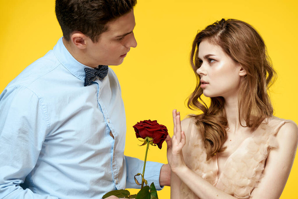 man and woman with red flower on yellow background bow tie model cropped view - Photo, Image