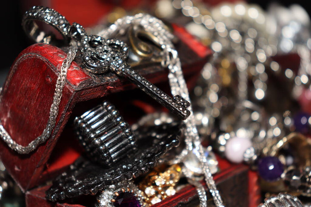 Plusieurs bijoux dans différents coffres avec anneaux, colliers, bracelets de différentes tailles et couleurs - Photo, image