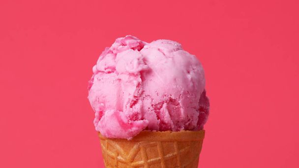 Strawberry Ice cream scoop in waffle cone on pink background. - Photo, Image
