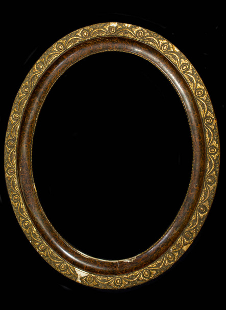 Old oval wooden picture frame isolated on black background. - Photo, Image
