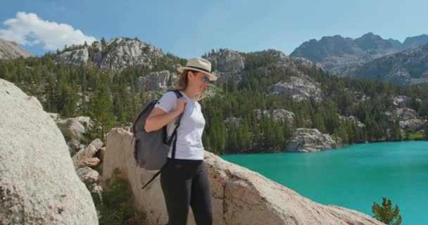 Mujer viajero feliz senderismo al lago de montaña azul escénico cinematográfico. Siente la libertad - Imágenes, Vídeo