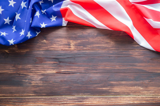 Detailní záběr americké vlajky je umístěn na levé straně s kopírovacím prostorem na dřevěném podstavci stolu. Čtvrtého července. Oslavte americký národní den. Svátek práce. Den nezávislosti. Memorial Day. - Fotografie, Obrázek