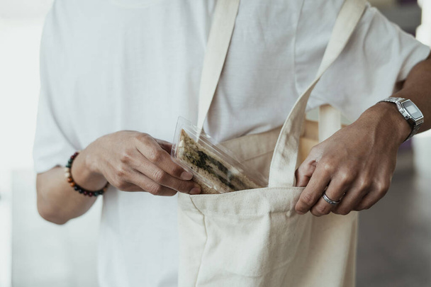Sebzeli sandviçin kırpılmış görüntüsü beyaz tuval torbasında saklanacak.. - Fotoğraf, Görsel