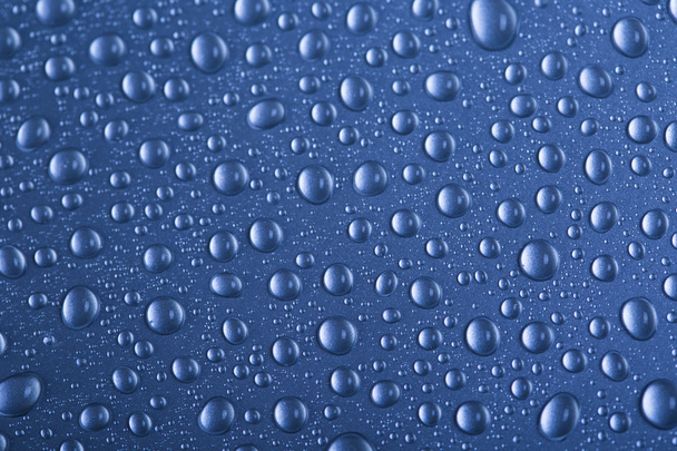 druppels water op blauwe achtergrond - Foto, afbeelding