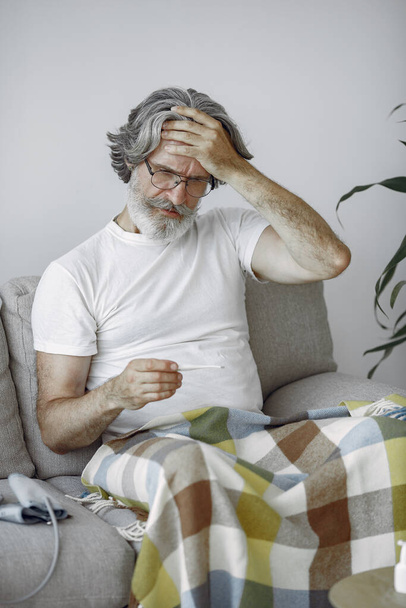 Old and sick senior man sitting at home - Foto, Imagem
