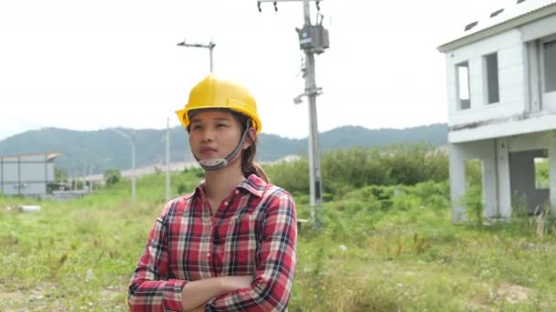 Langsame Aufnahmen von der Überprüfung der Baustelle, asiatische Ingenieurin in Helmen, die über die Baustelle läuft  - Filmmaterial, Video