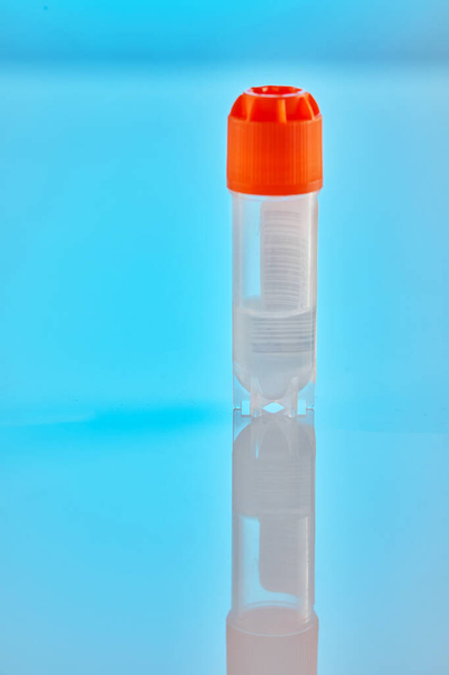 DNA test. Test tube with liquid for DNA analysis on a blue background with reflection. - Фото, изображение