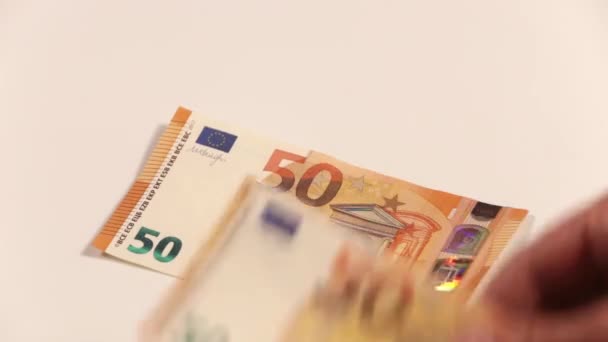 Mužské ruce počítání množství hotovosti v 50 eurobankovky na bílém pozadí. - Záběry, video