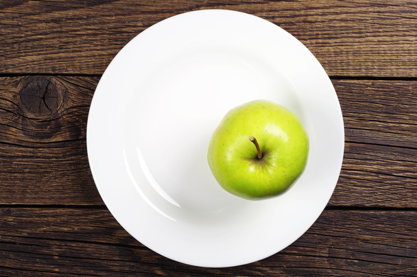 Green apple on a plate - Photo, image