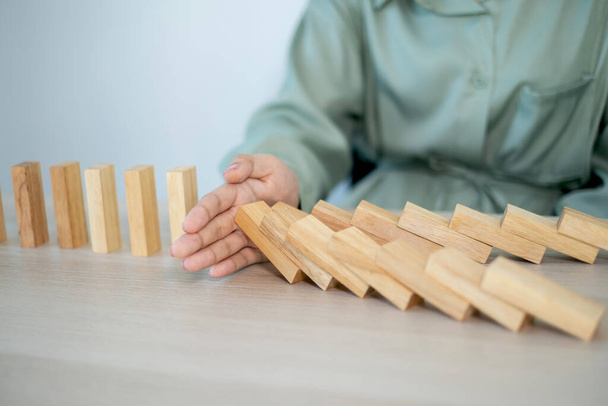 Businesswoman hand stop wooden blocks for protect other wooden block, Concept Risk of management and strategy plan. - Photo, Image