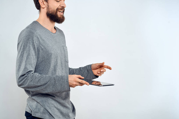 Mann mit Tablet in den Händen Technologie Lifestyle Internet Kommunikation Arbeit Licht Hintergrund beschnitten Ansicht - Foto, Bild