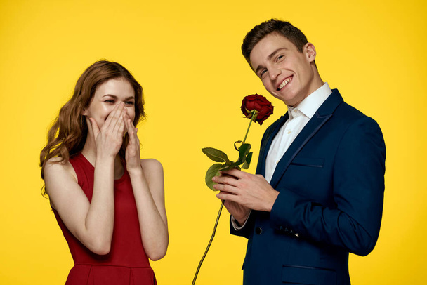 Закохані чоловіки жінка з червоною трояндою в руках романтичні свята жовтий фон сімейні друзі
. - Фото, зображення