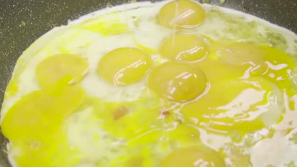 Slow-motion video van het breken van kippeneieren in een koekenpan met uien, kruiden en specerijen.Roerei, Frittata, omelet of gebakken eieren.Bereiding van dieetvoeding, vegetarisch voedsel - Video