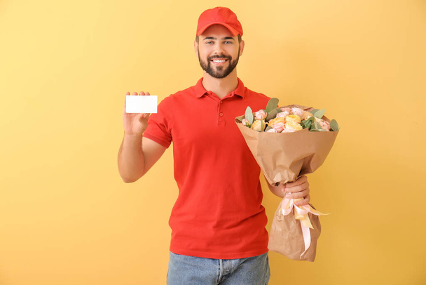 Delivery man with bouquet of flowers and business card on color background - Фото, изображение