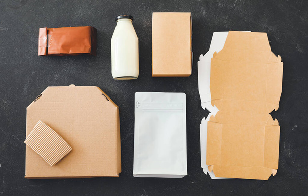 Koyu arkaplanda yiyecek ve süt paketleri - Fotoğraf, Görsel