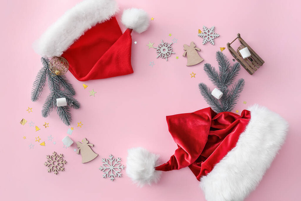 Різдвяна композиція з капелюхами Санта Клауса на кольоровому фоні. - Фото, зображення