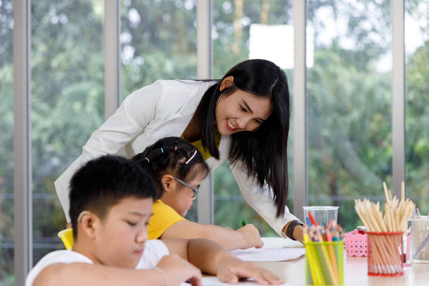 Sınıfta sanat dersi veren Asyalı kadın öğretmen. Çocukların okulda öğrenmesi kavramı. - Fotoğraf, Görsel