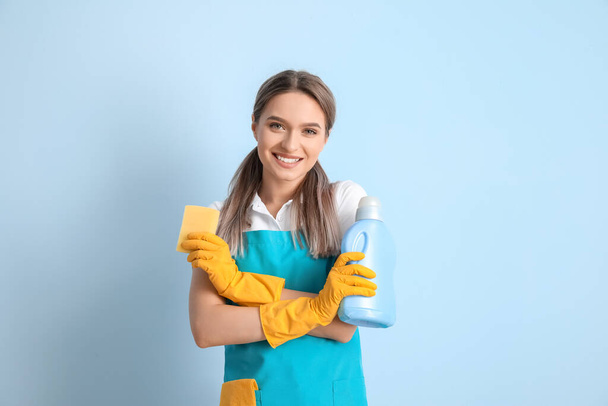 Nuori nainen siivoustarvikkeet värillä taustalla - Valokuva, kuva
