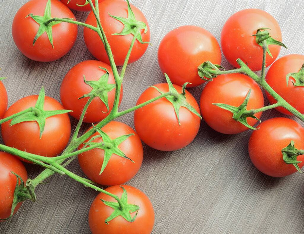 Cherrys tomaatit haara puinen pöytä. - Valokuva, kuva