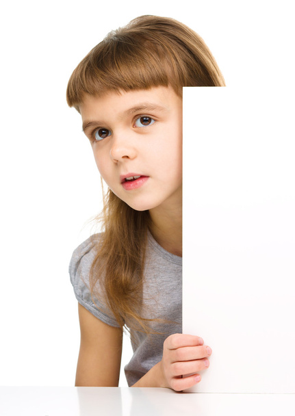 Little girl is looking out from the blank banner - Photo, image