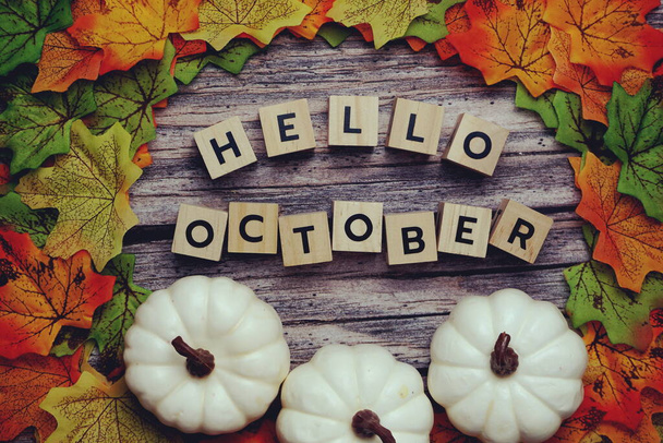 Hello October alphabet letter with pumpkin and maple leaves decoration on wooden background - Foto, Imagem