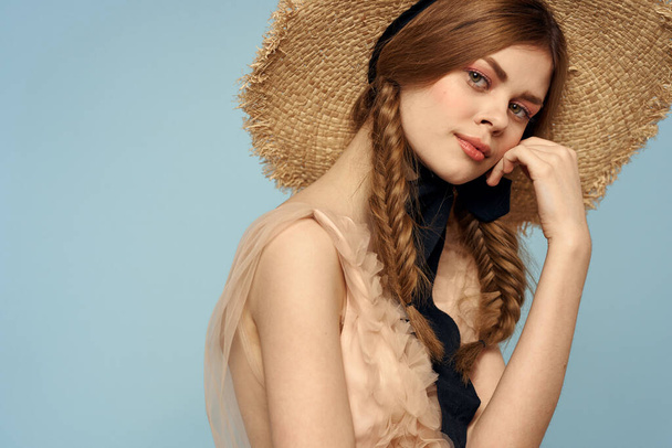 Ρομαντικό κορίτσι σε ένα ψάθινο καπέλο σε γκρι φόντο και ένα μπεζ sundress μαύρο κορδέλα συναισθήματα μοντέλο - Φωτογραφία, εικόνα