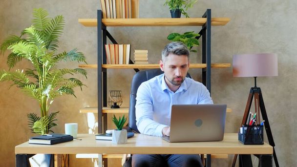 Mann arbeitet ferngesteuert online mit Laptop-Computereingabe auf Tastatur - Foto, Bild