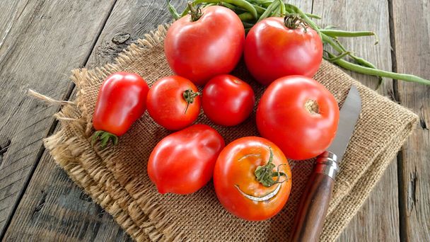 group of fresh tomatoes on a wooden table - 写真・画像