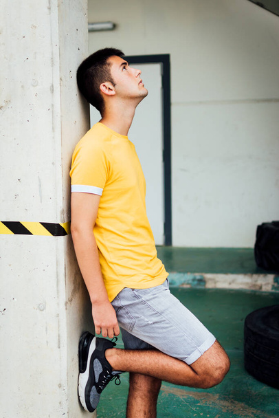 Adolescente en camiseta amarilla y pantalones cortos mirando al cielo - Foto, Imagen
