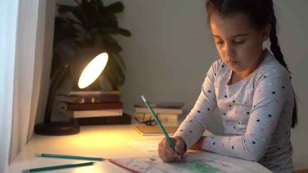 かわいいスマート小学生の女の子の書き方を学ぶ数学の宿題を書いて自宅のテーブルに座って、かわいい小さな就学前の子供はノートを作るだけで勉強し、子供の小学校の教育の概念 - 映像、動画