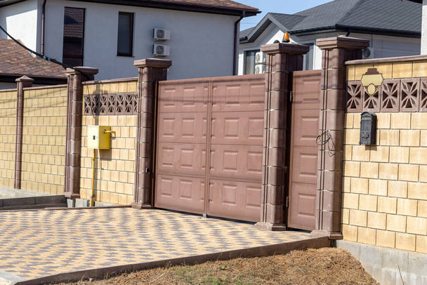 Prefabricated concrete, stone, brick new modern expensive outdoor fence to street. Wall of fence is sectional plastered with embossed road putty. Place text, concept of wealth, protection; Reliability - Photo, Image