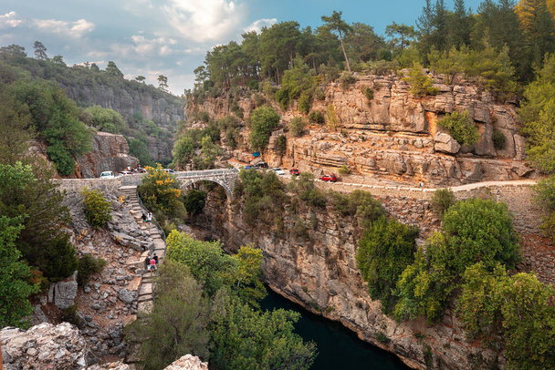 Starożytny most łukowy nad wąwozem rzeki Koprucay w Parku Narodowym Koprulu w Turcji. Panoramiczny widok na kanion i błękitną burzliwą górską rzekę - Zdjęcie, obraz