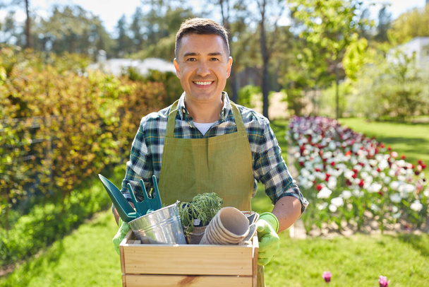 happy man with tools in box at summer garden - Фото, зображення