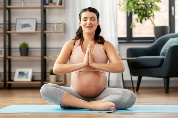 happy pregnant woman meditating at home - Фото, изображение