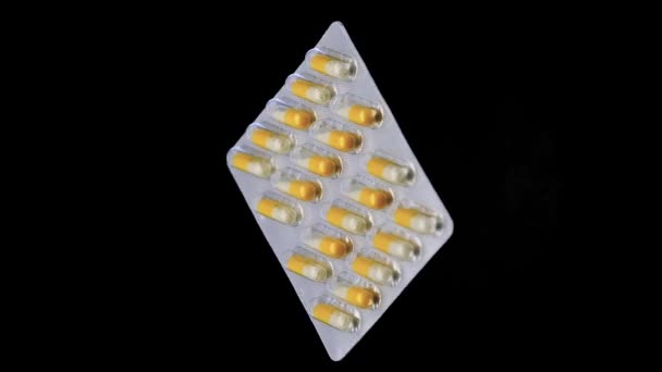 Blisterpackung mit Tabletten dreht sich auf schwarzem Hintergrund. - Filmmaterial, Video