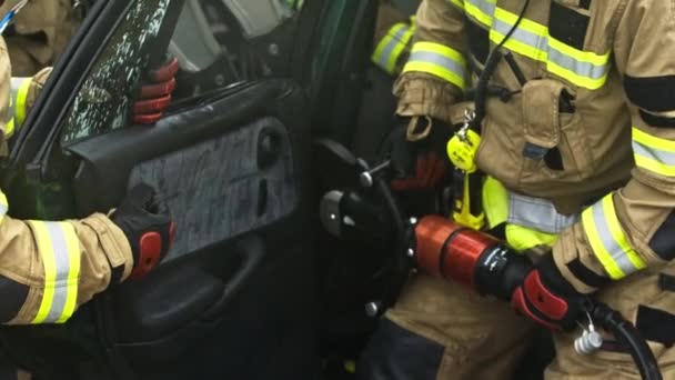 Palomiehet leikkaavat auton ovia pelastaakseen auto-onnettomuuden - Materiaali, video