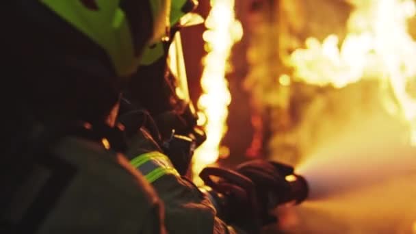 Tűzoltó oltsa el a tüzet a tömlővel. Égő házi tűzriadó - Felvétel, videó
