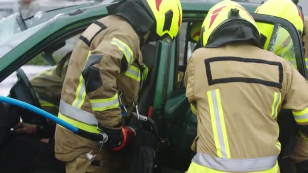 Firefighters using jaws of life to extricate trapped victim from the car - Footage, Video