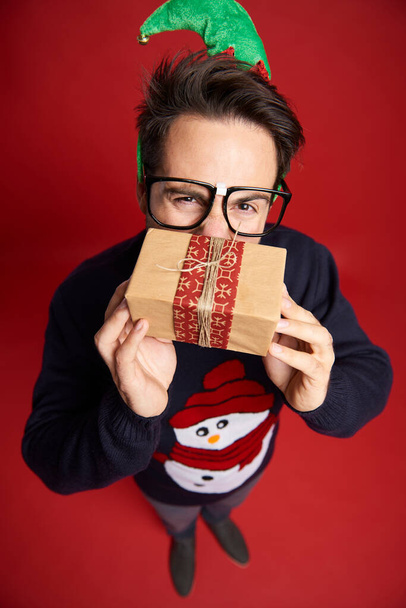 Vista de ángulo alto del hombre nerd con pequeño regalo de Navidad - Foto, imagen